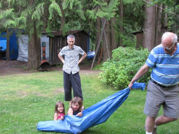 Opa pulling his Granddaughters across our Yard